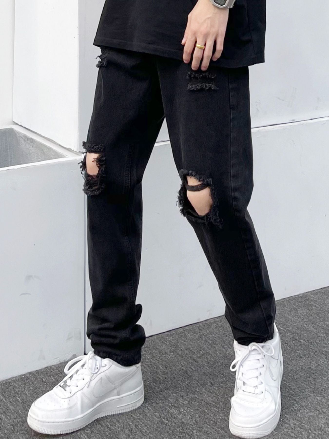 Black distressed slim fit jeans made of 100 cotton with ripped details.