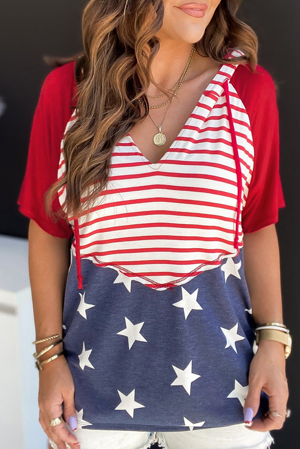 Patriotic raglan hooded tee with red sleeves, white and red striped body, and blue star print bottom.
