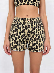 Leopard print high-waisted denim shorts with raw hem and button fly.