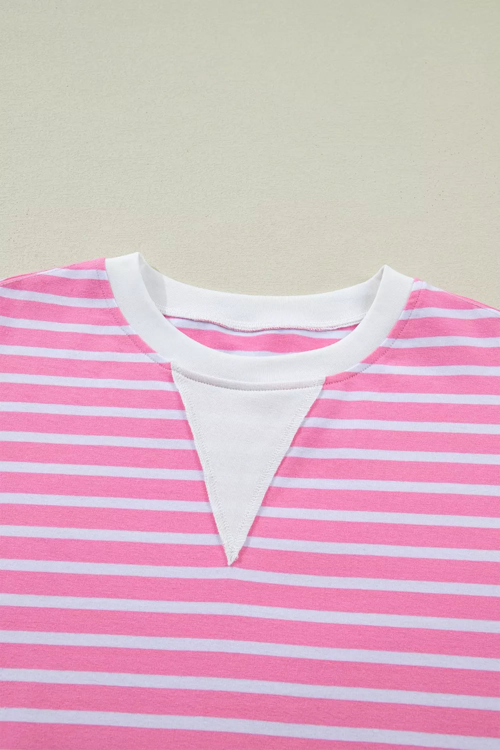 Pink and white striped cotton t-shirt with round neck and white inset detail.