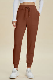 Caramel joggers with drawstring waist and cuffed ankles, styled with white sneakers.
