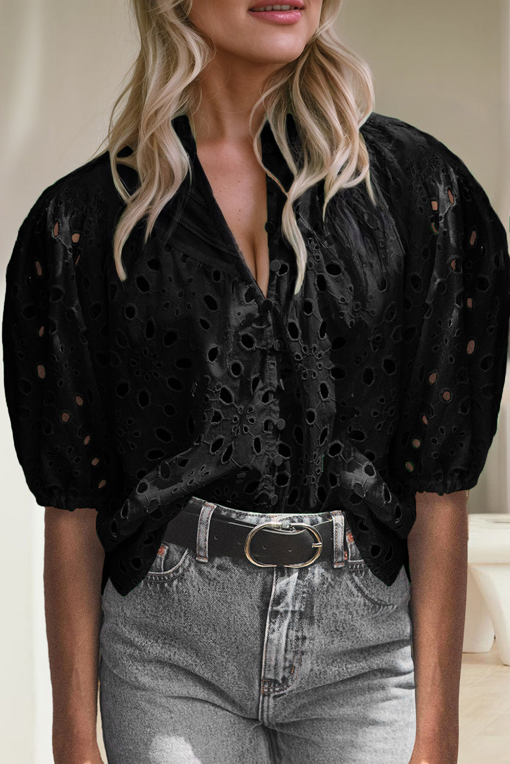 Black eyelet puff-sleeve blouse with stand collar and button front, styled with jeans.