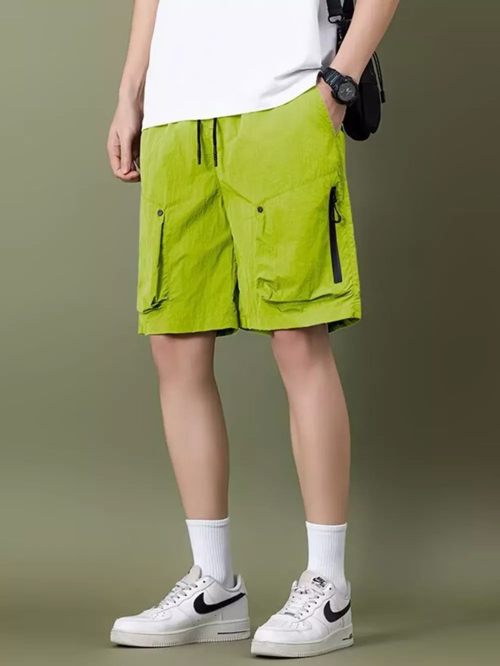 Green lightweight cargo shorts with zipper pockets and drawstring waist.