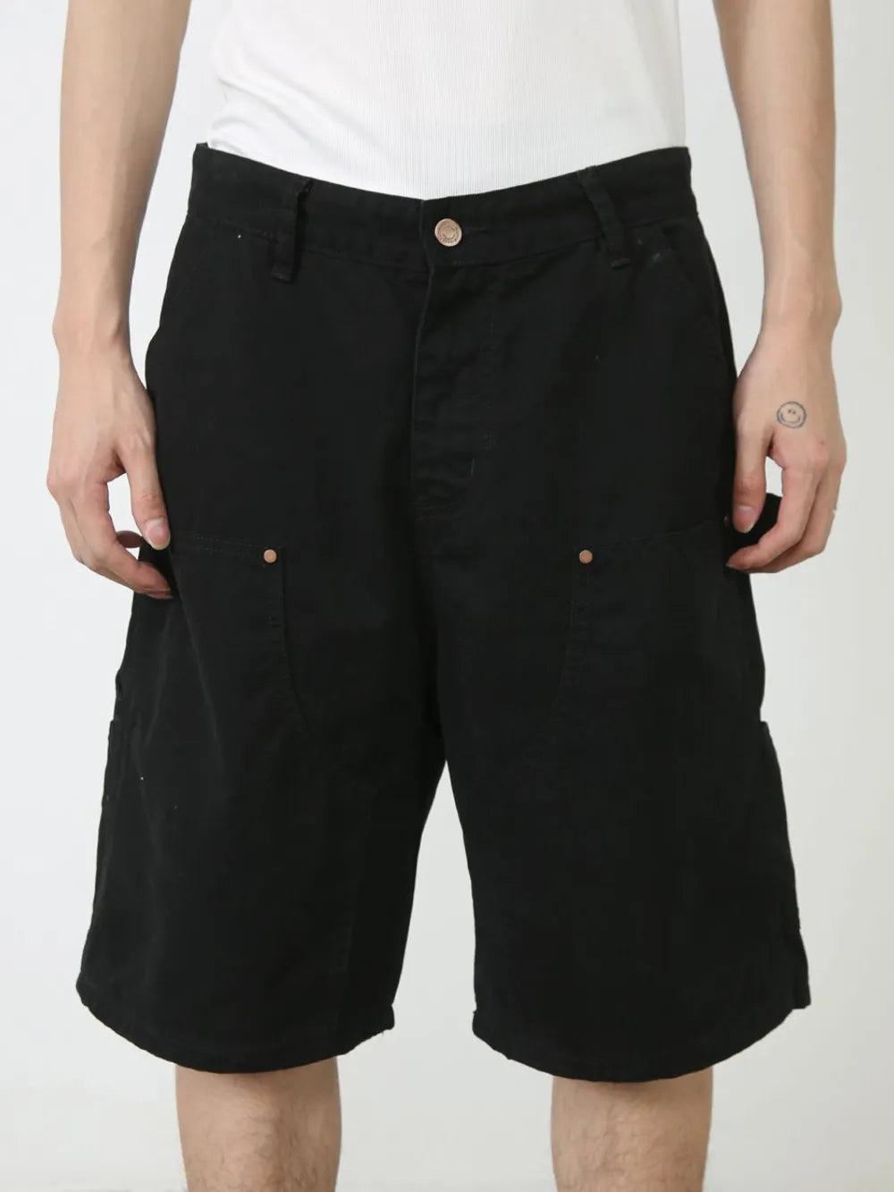 Black denim carpenter shorts with button fly and utility pockets.