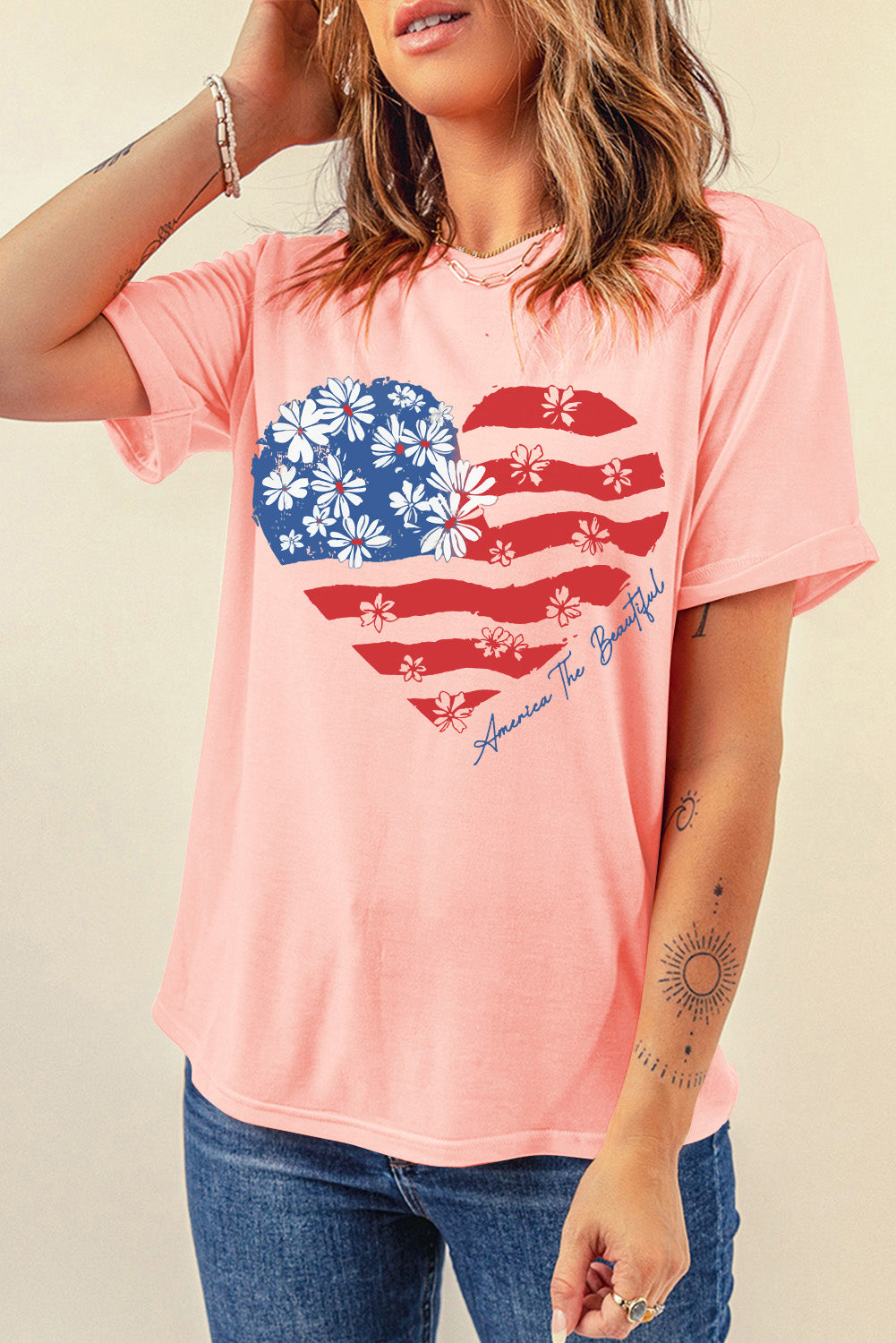Pink t-shirt with a floral American flag heart graphic and text.