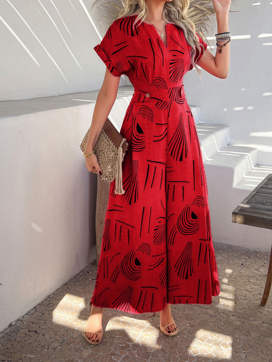 Scarlet wide-leg jumpsuit with geometric print, V-neck, and short sleeves.