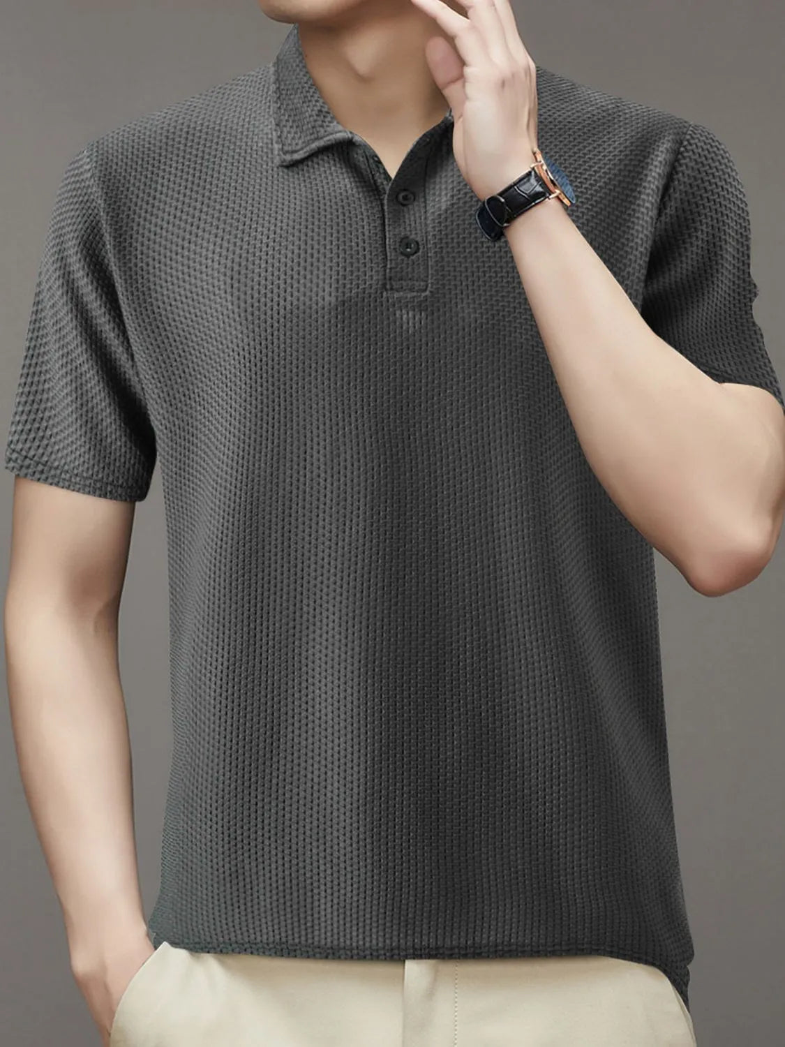 Dark gray textured knit polo shirt with short sleeves and a button placket.