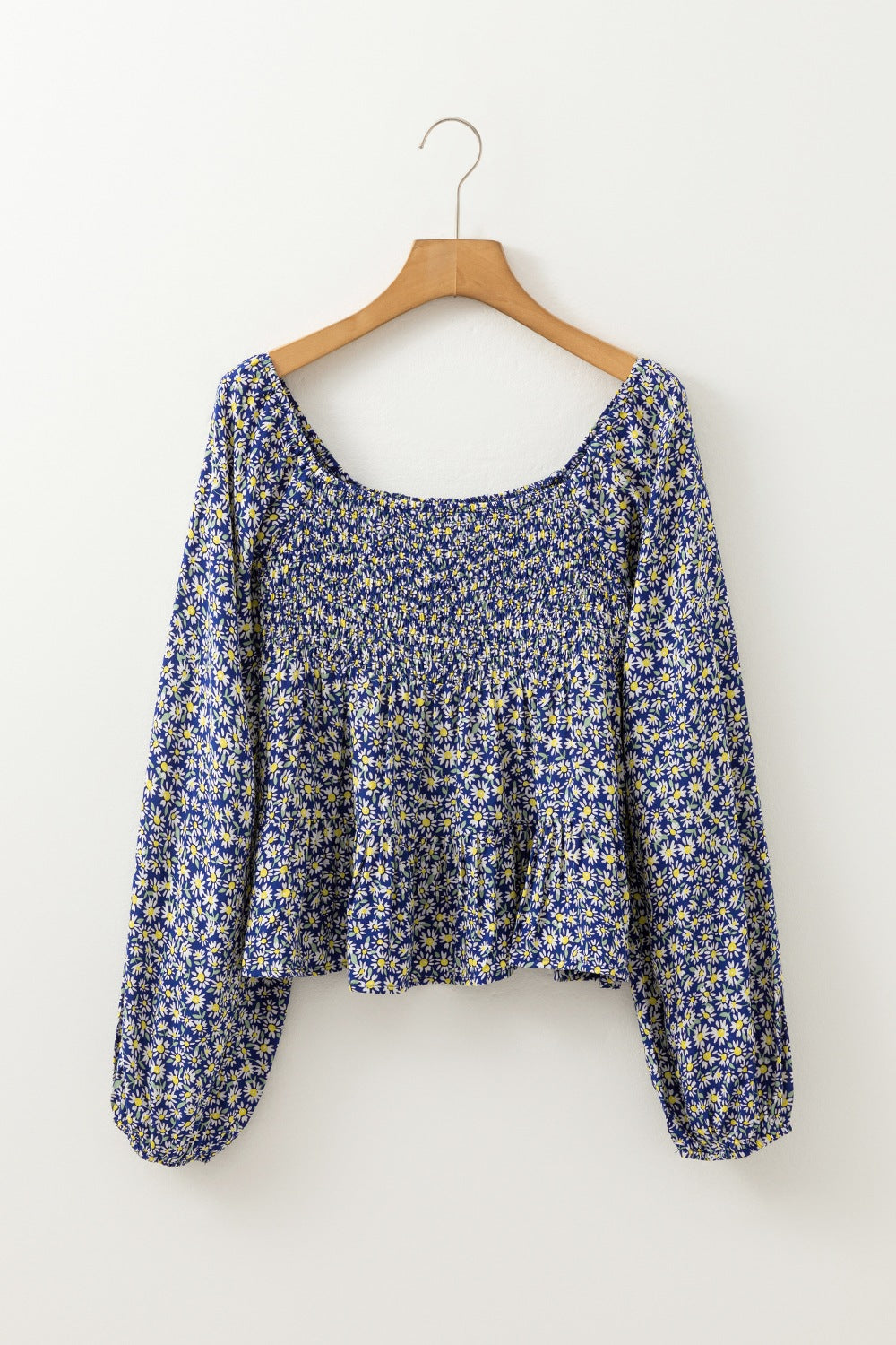 Daisy print smocked peplum blouse in dusty blue with square neckline and long sleeves.