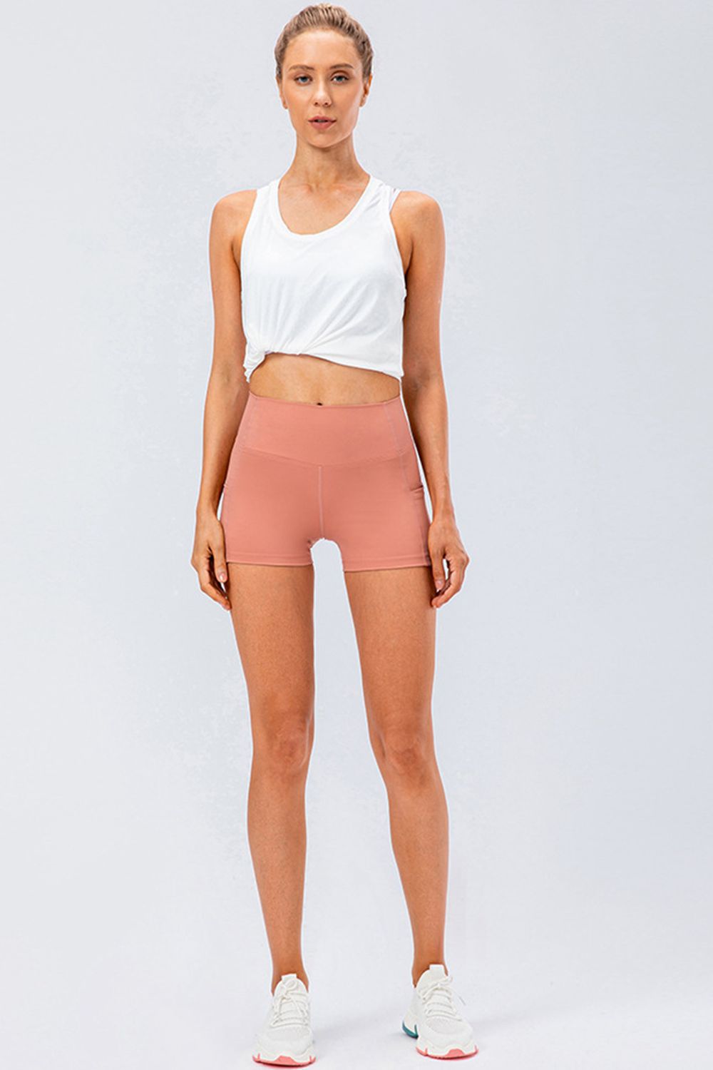Sculpted performance shorts in Coral with side pockets and a high waist.
