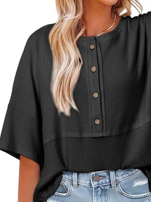 Black waffle-knit t-shirt with button detail and textured hem.