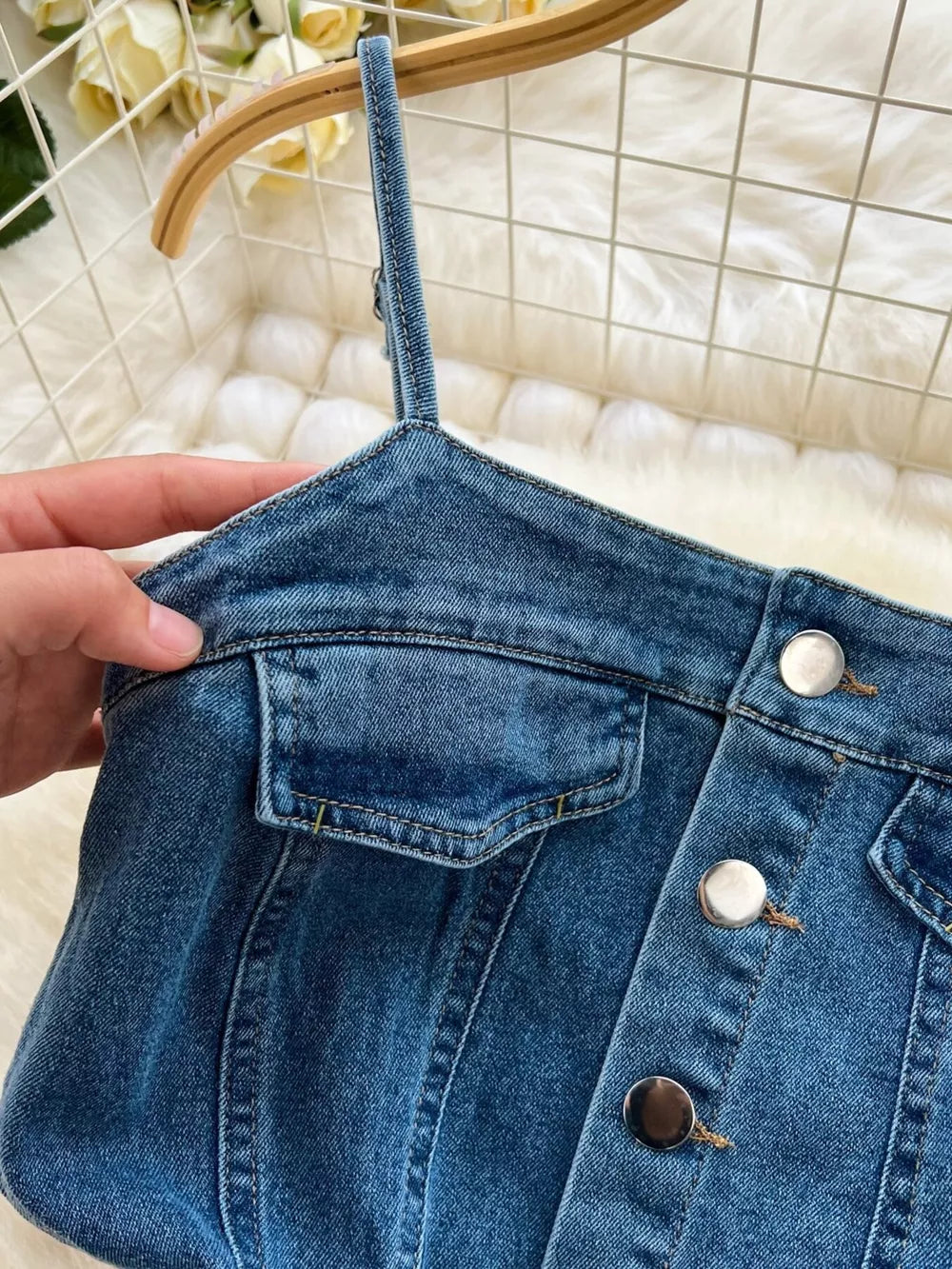 Denim maxi dress with button front, chest pockets, and spaghetti straps.