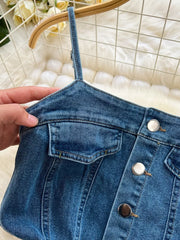 Denim maxi dress with button front, chest pockets, and spaghetti straps.