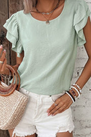 Sage flutter sleeve blouse with textured fabric and round neckline.