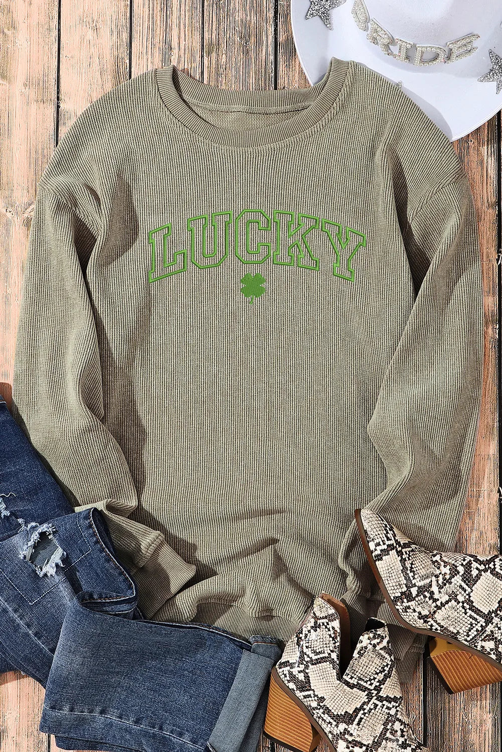 Light green ribbed crewneck sweatshirt with "LUCKY" graphic and shamrock detail.