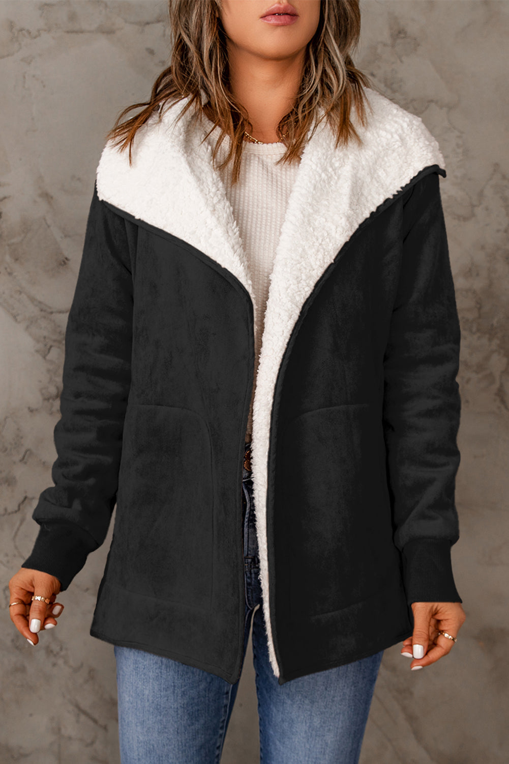 Black suede-effect jacket with sherpa collar and lining, open front, long sleeves, and pockets.
