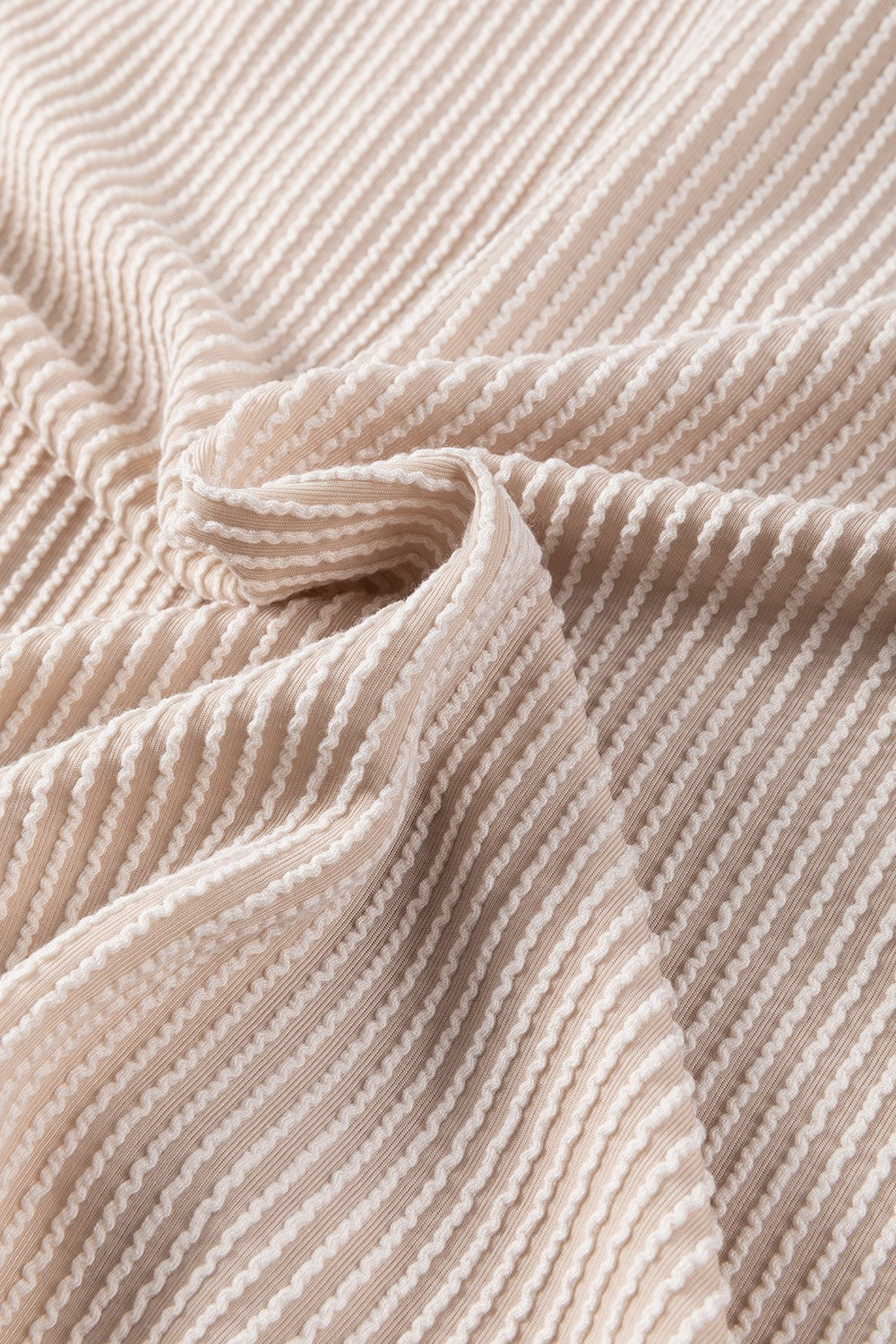 Tan textured knit fabric with white ribbed stripes, showing material detail.