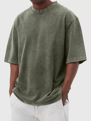 Men's oversized green vintage wash cotton crew neck t-shirt with raw hem detail.