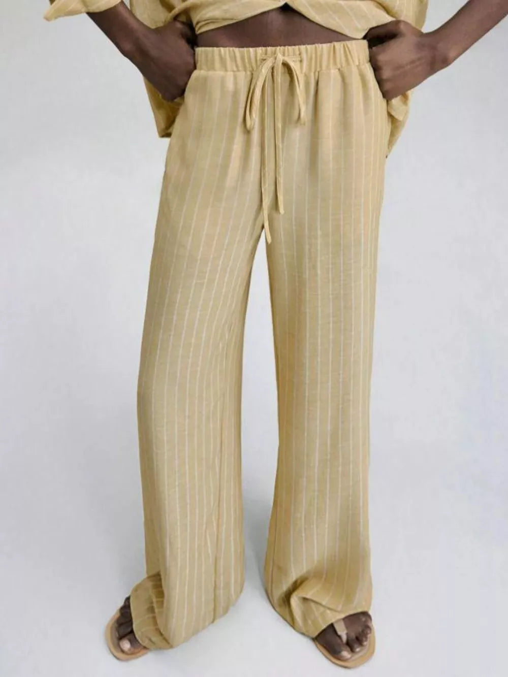 Chic striped two-piece set with drawstring waist pants and a button-down top.