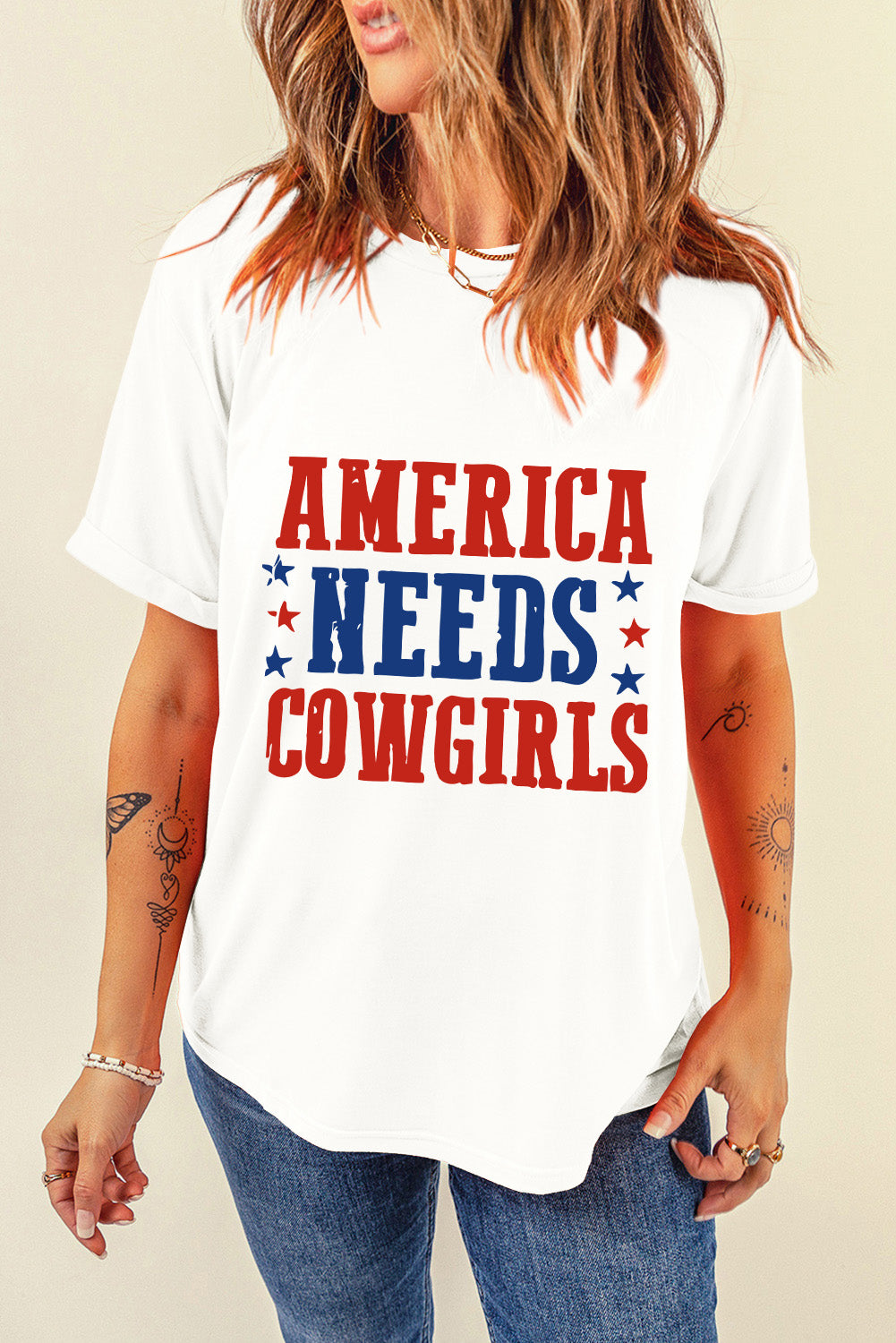 White graphic t-shirt with red and blue "America Needs Cowgirls" text and stars.
