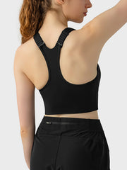 Black zip-front racerback sports bra with adjustable straps and a cropped fit.