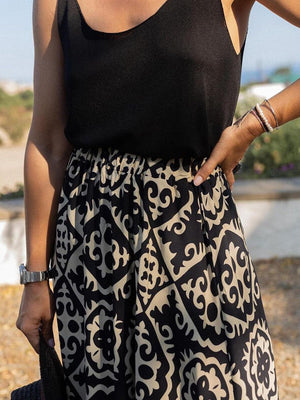 Tiered maxi skirt in black with beige medallion print and elastic waist.