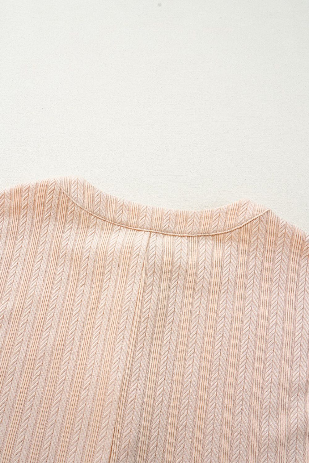 Textured ribbed sleeveless collar jumpsuit in eggshell with a button detail.