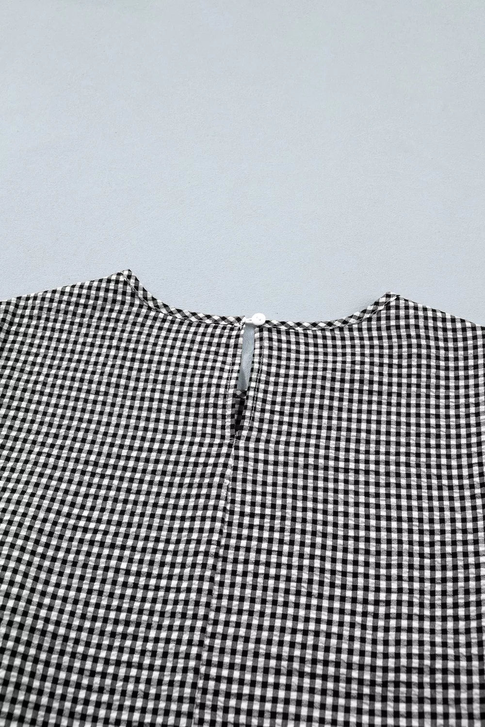 Gingham shirt with ruffled sleeves and bow tie neck detail.