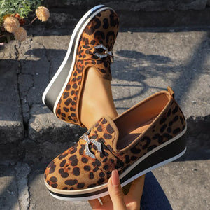 Leopard print wedge loafers with buckle detail in brown, featuring a platform sole.