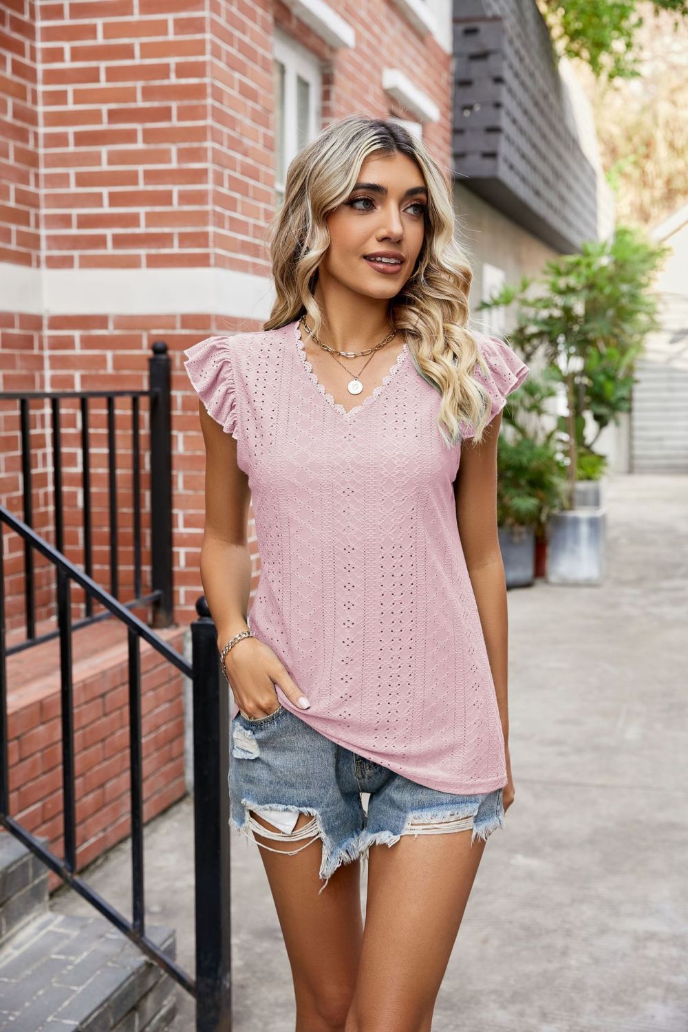 Blush pink eyelet blouse with lace trim and flutter sleeves.