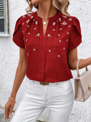 Rust embroidered floral keyhole blouse with flutter sleeves and a V-neck.