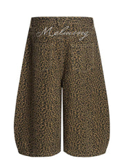 Men's brown leopard print wide-leg capri track pants with white script detail on back waistband.
