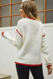 Cream acrylic crewneck sweater with red contrast trim on neckline, cuffs, and hem.