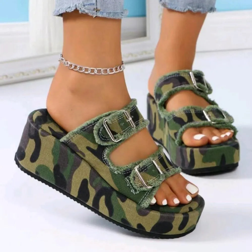Denim platform slides in camouflage print with double buckle straps and frayed edges.