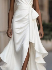 White halter maxi dress with ruffled asymmetrical skirt and belted waist.