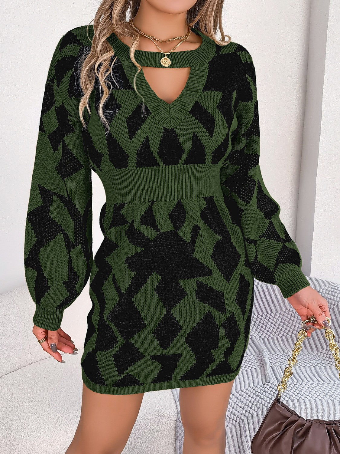 Army green knit mini dress with black geometric pattern, v-neck cutout, and long sleeves.