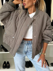 Taupe quilted bomber jacket with rounded sleeves and ribbed cuffs.
