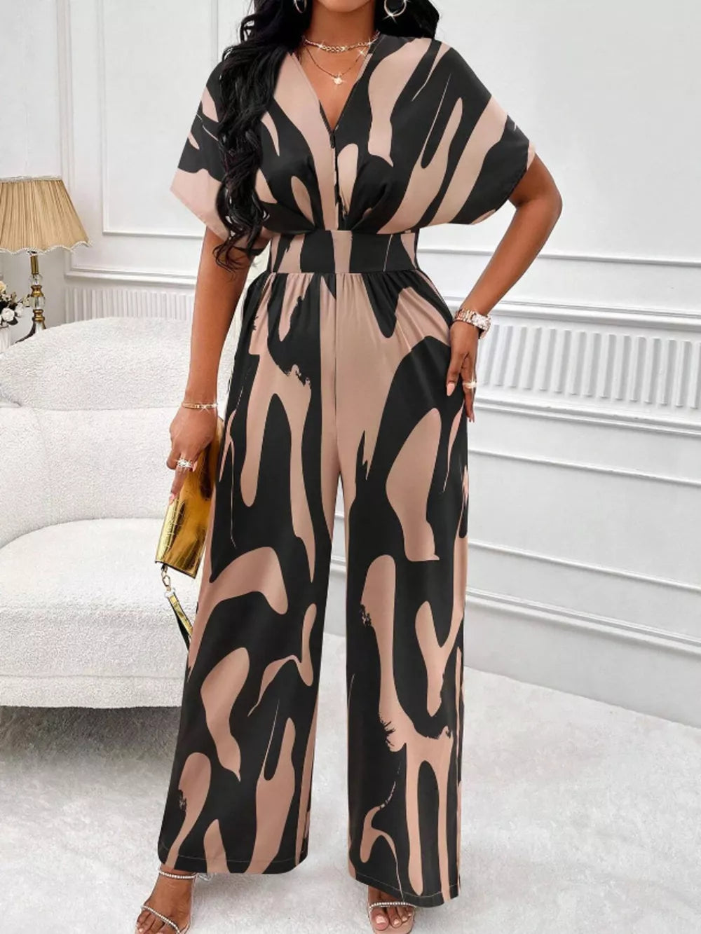 Chic abstract print wide-leg romper in black and khaki with V-neck and short sleeves.