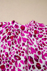 Vibrant leopard print V-neck blouse with a gathered neckline and flowy fit.