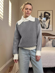 Striped knit sweater in black with a contrast white collar and cuffs.