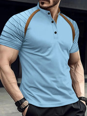 Light blue polo shirt with brown contrast raglan sleeves and mandarin collar.