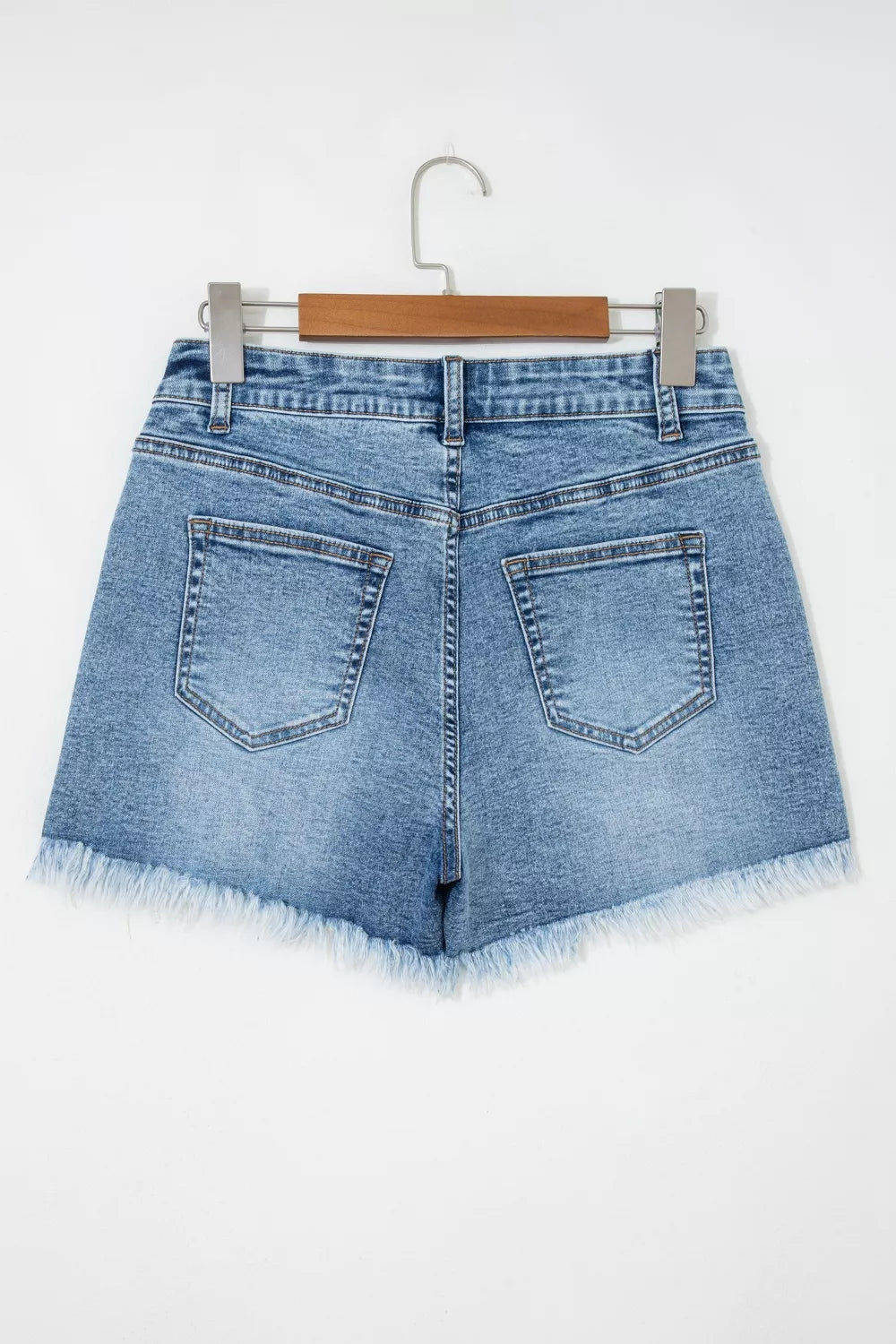 Blue denim shorts with distressed details and frayed hem