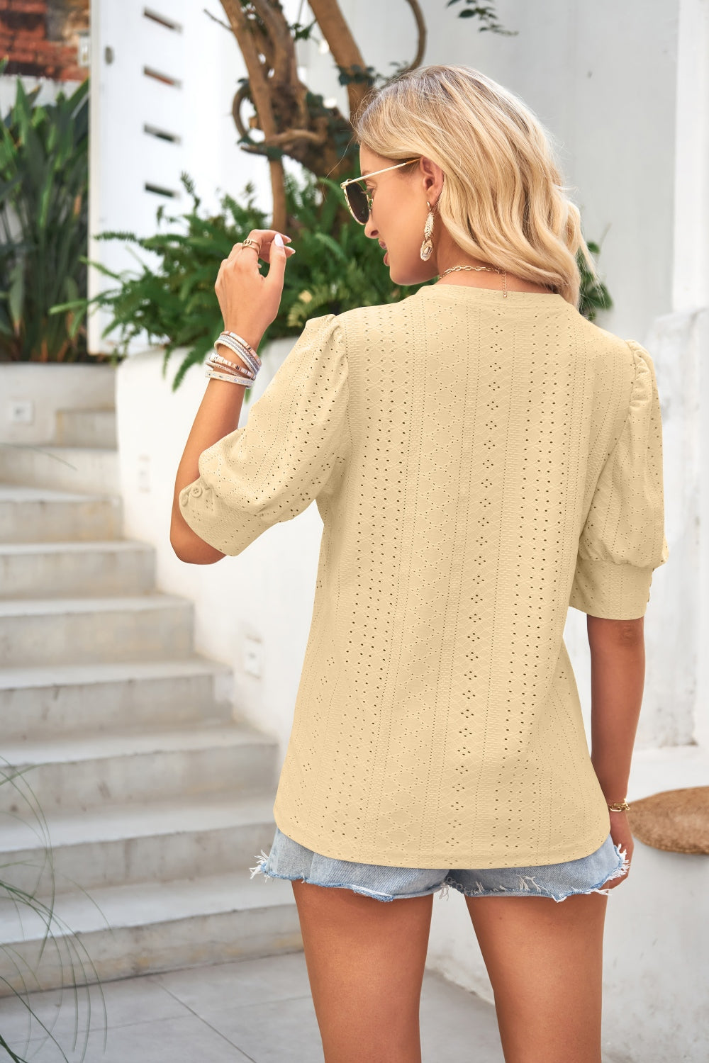 Light yellow eyelet puff sleeve blouse with short sleeves and a mock neck.