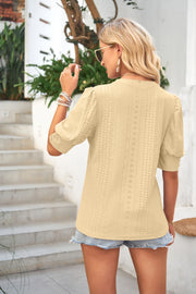 Light yellow eyelet puff sleeve blouse with short sleeves and a mock neck.