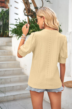 Light yellow eyelet puff sleeve blouse with short sleeves and a mock neck.