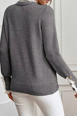 Dark gray knit sweater with mock neck, lace trim at collar and cuffs, and gold button details.