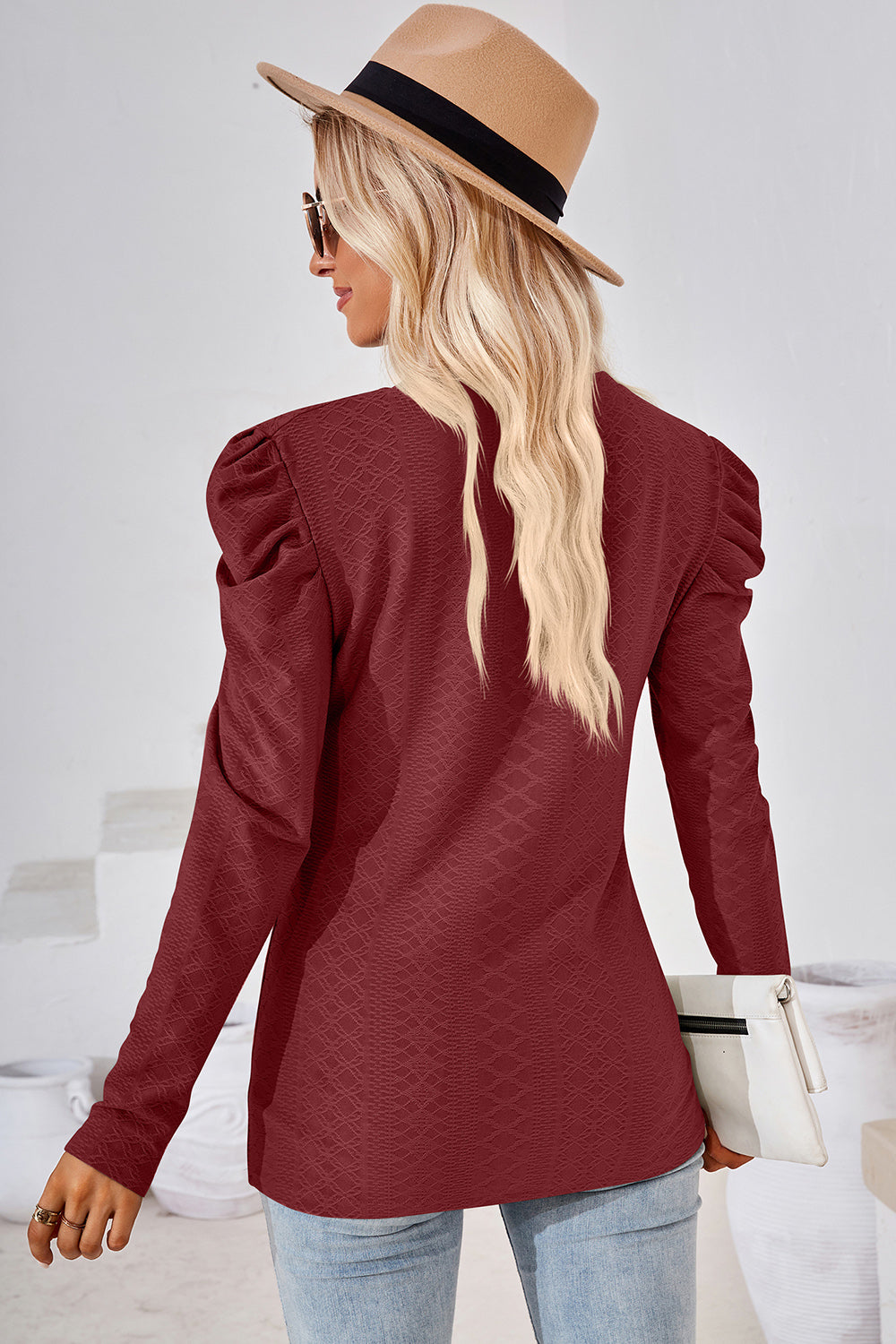Burgundy textured puff-sleeve crew neck blouse with long sleeves.