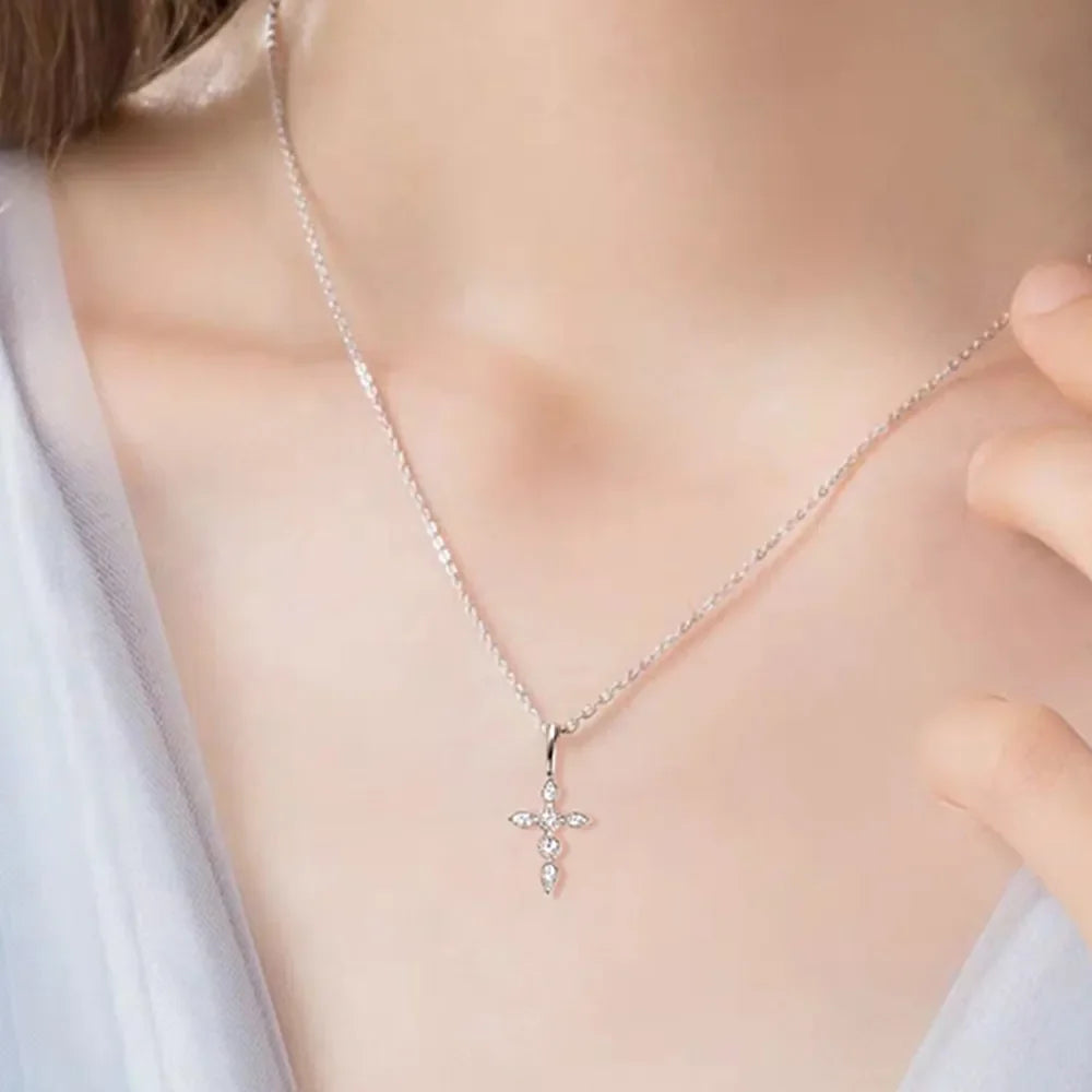 Silver diamond-set cross pendant necklace with a delicate chain.