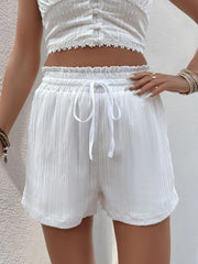 White textured shorts with elastic waistband and drawstring.
