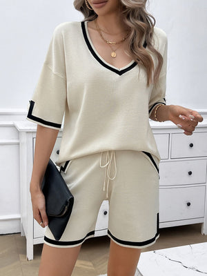 Cream knit loungewear set with black contrast trim, V-neck top and drawstring shorts.