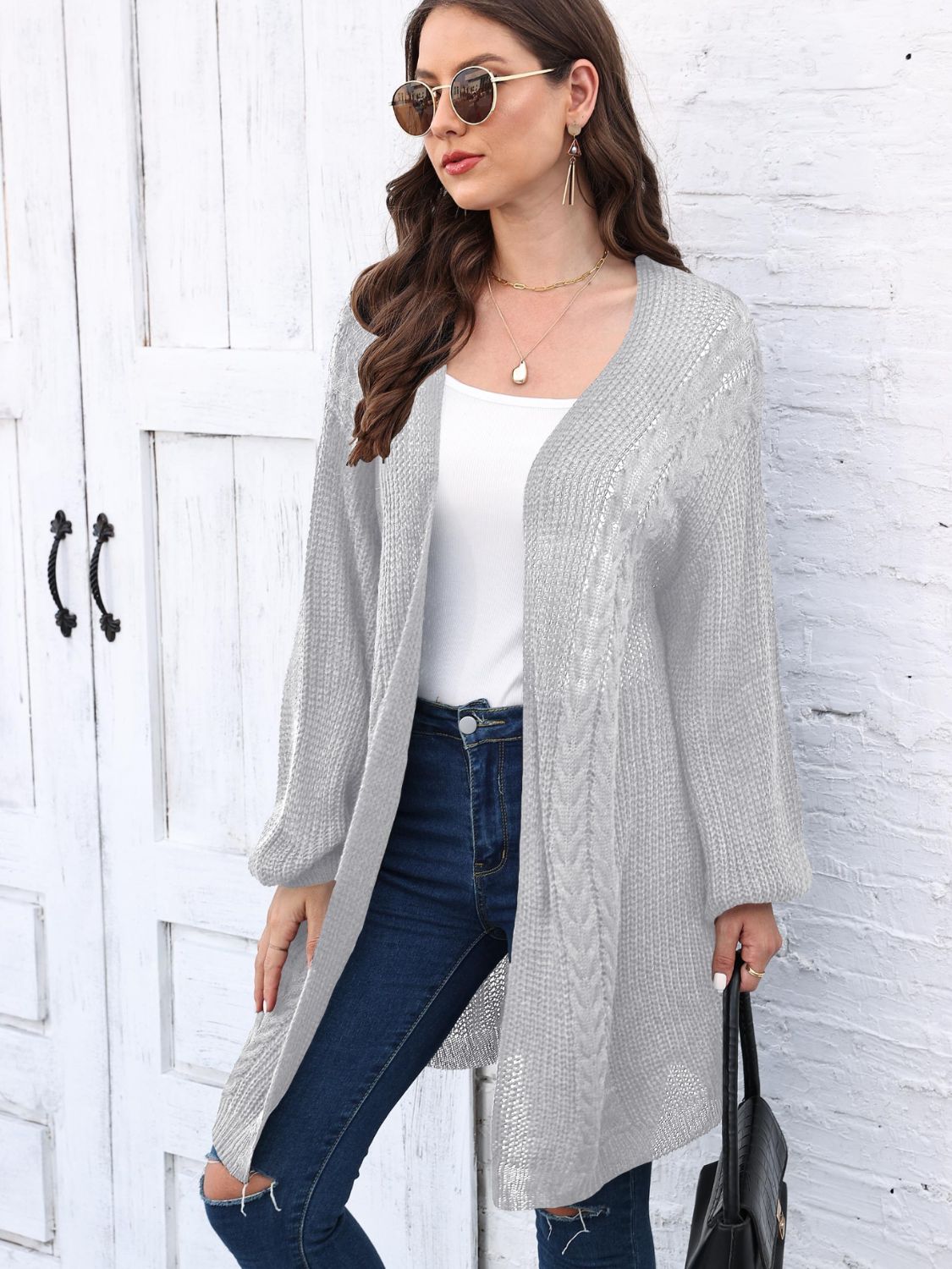 Light gray acrylic cable knit cocoon cardigan with open front and long sleeves.